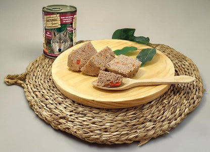 Lupiora Natural Greatness Nassfutter mit Kaninchen, Hirsch, Karotten und Oliven auf einem Holzbrett serviert
