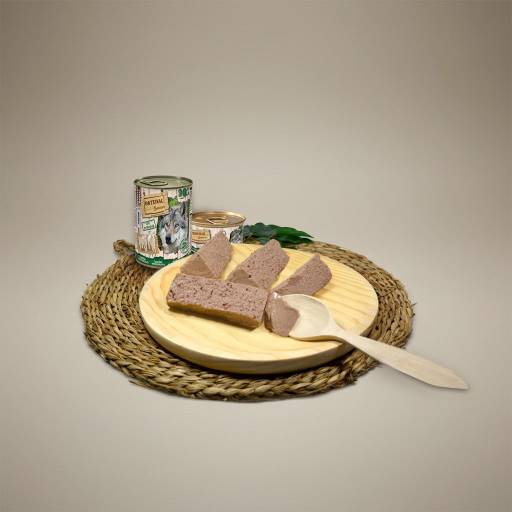 Lupiora NATURAL GREATNESS Lamm Monoprotein Mousse für Hunde auf einem Holzbrett mit Holzlöffel serviert.